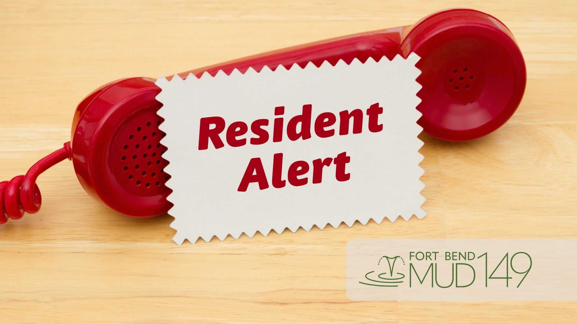 Red telephone handset on a wooden surface with a sign reading “Resident Alert” between the earpieces and the Fort Bend MUD 149 logo in the lower-right corner.